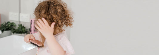 child brushing curly hair